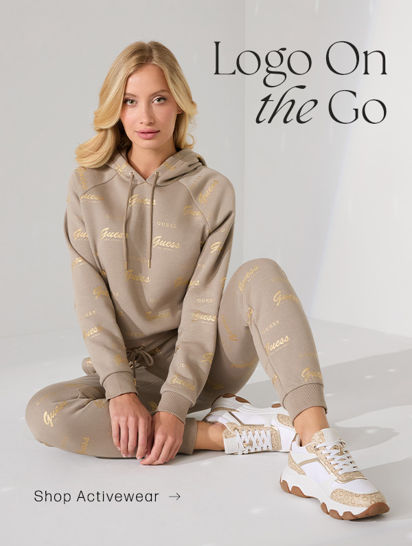 image of a model in a tan hoodie with metallic logo print and matching knit joggers