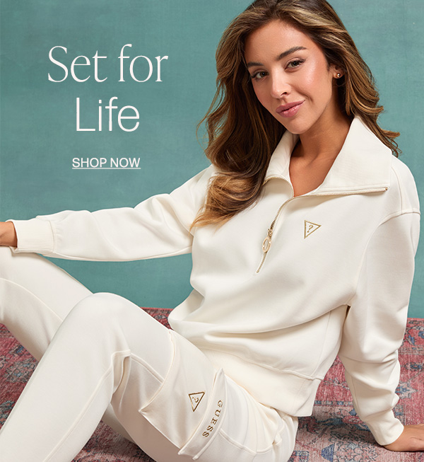  image of a model in a white activewear set with half-zip sweatshirt and cargo joggers