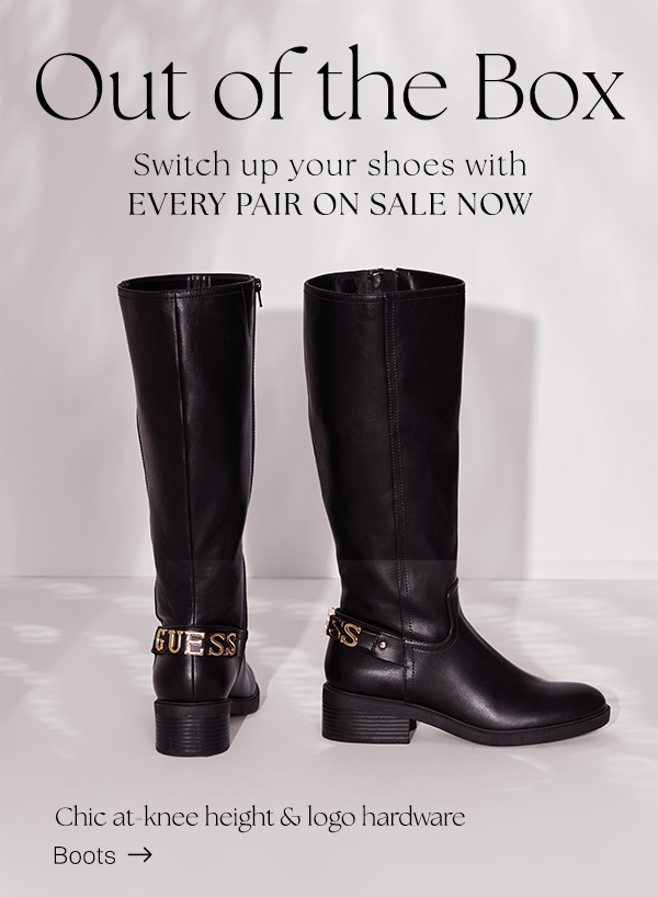 image of a pair of black faux-leather riding boots with logo emblem heel detail