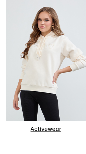 image of a model in a cream hoodie with logo and black leggings